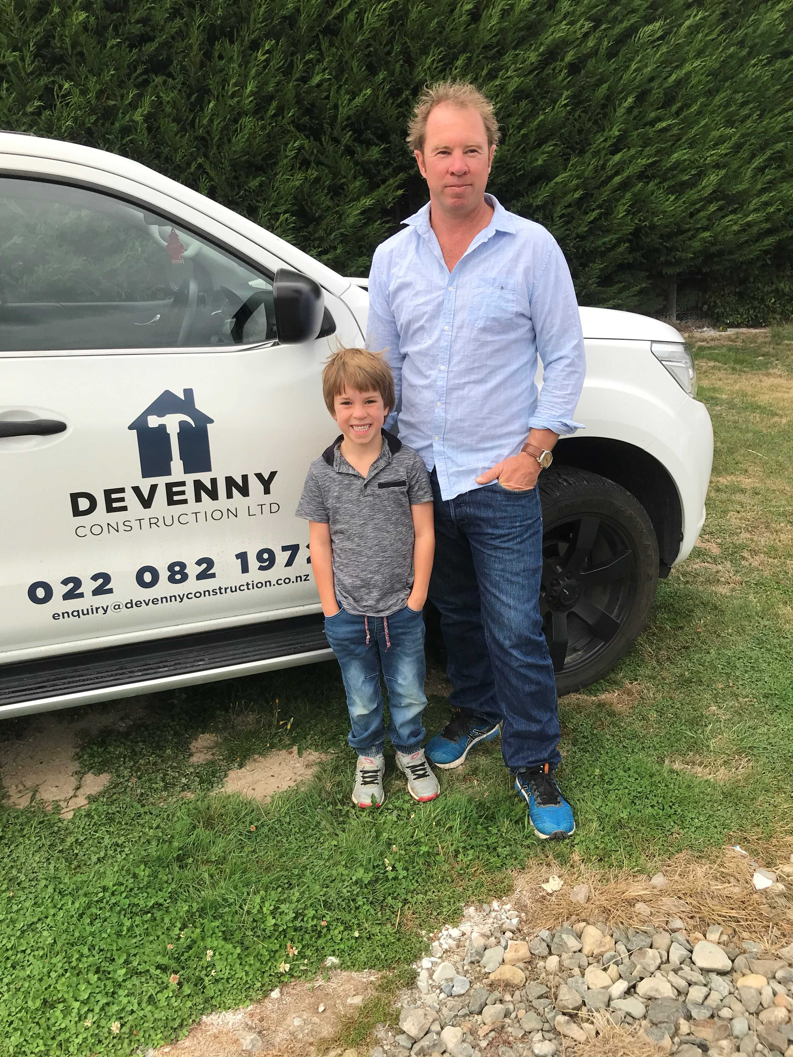 James at Maximus standing in front of Devenny Construction vehicle